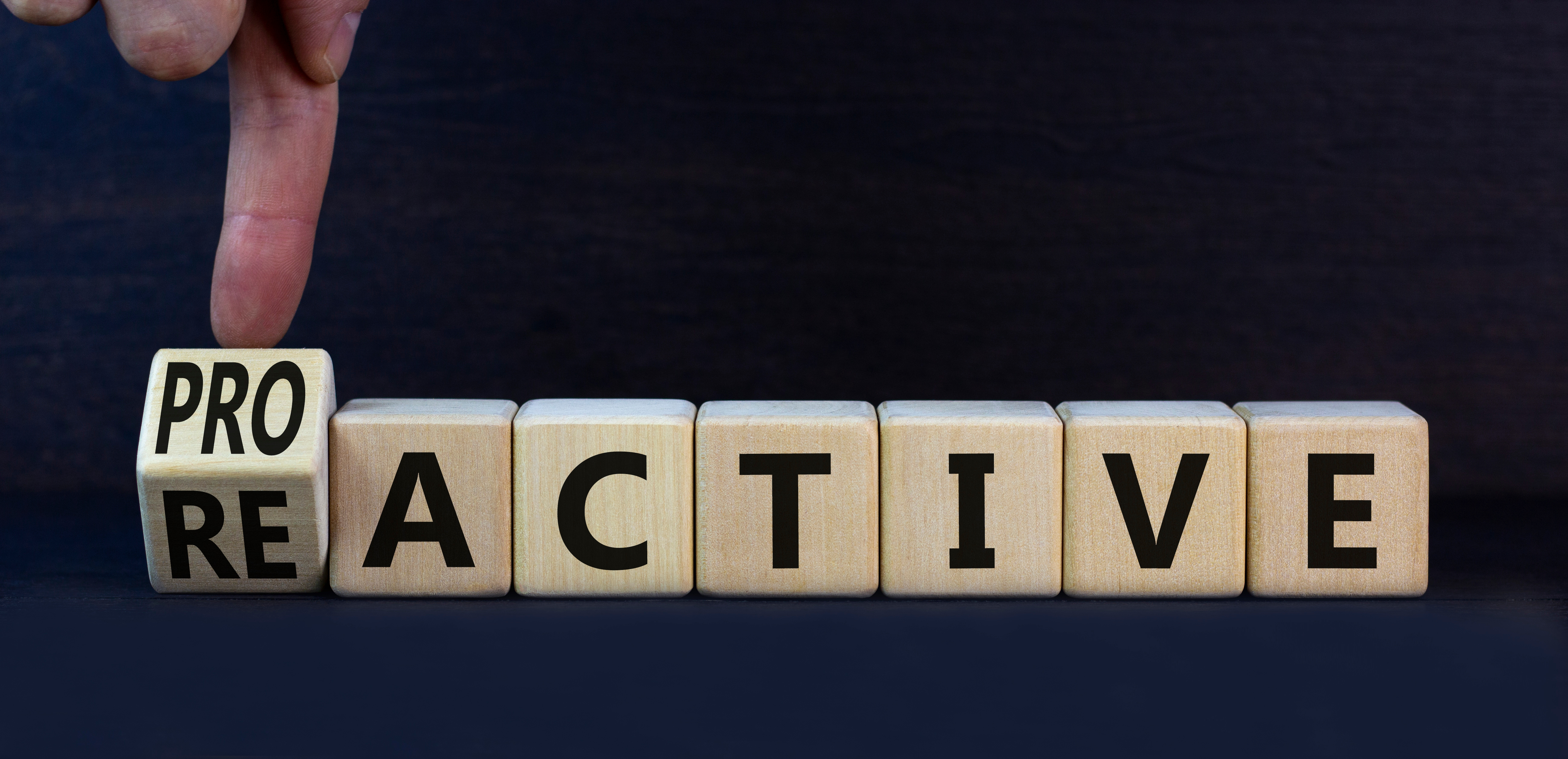Reactive or proactive symbol. Turned wooden cubes and changed the concept word reactive to proactive. Beautiful grey table grey background, copy space.Business and reactive or proactive concept.